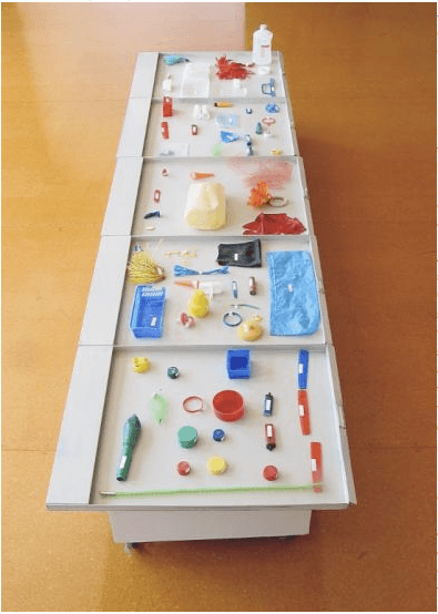 A long table with various objects on it.
