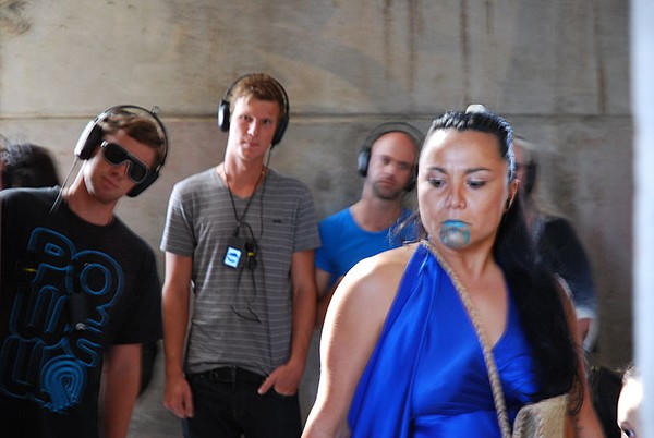 A group of people wearing headphones and a woman in a blue dress.