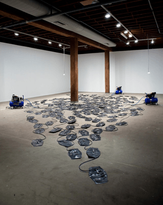 A series of objects on the floor of a gallery.